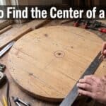 Person measuring the center of a wooden circle with a ruler and tools.