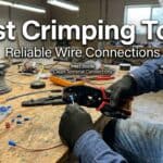 Person using crimping tool on wire in workshop setting.