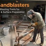 Person using a sandblaster for rust removal on metal surface.