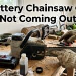 Person inspecting a chainsaw with oil issues on a workbench.