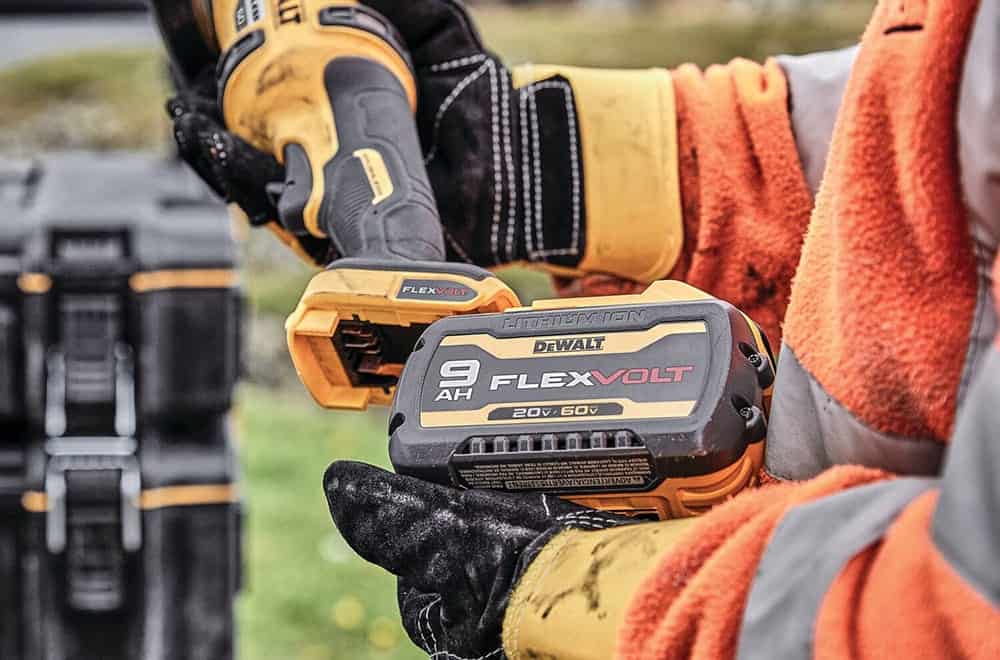 Person holding DeWalt 20V FLEXVOLT battery for power tools.